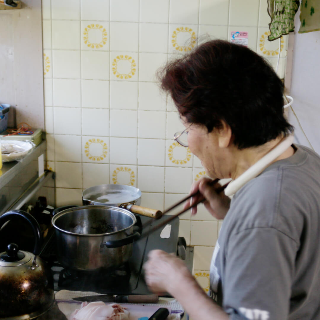 菜箸を持ち豚汁をつくりはじめるお母さん
