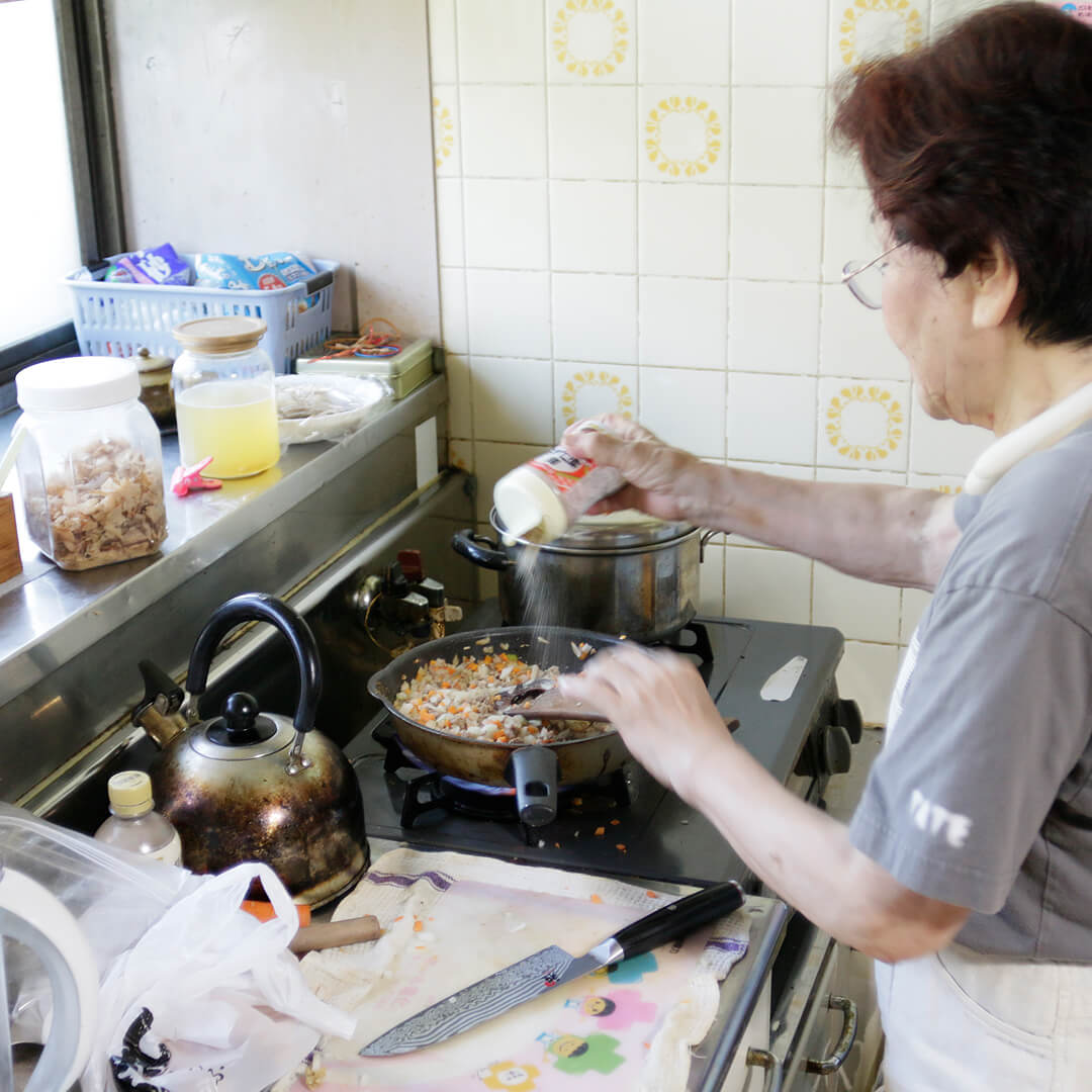 味塩コショウをふるお母さん